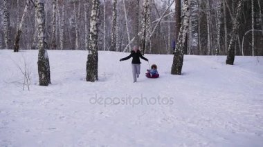 mutlu aile rides ve karlı roads.slow hareket üzerinde gülümseyen snowtube. kar kış manzara. açık havada spor
