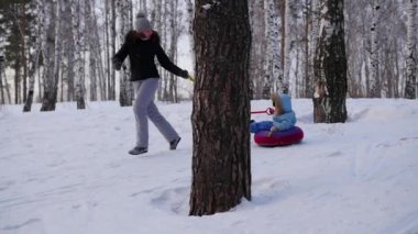 mutlu aile rides ve karlı roads.slow hareket üzerinde gülümseyen snowtube. kar kış manzara. açık havada spor