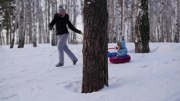 Šťastné rodinné jízdy a usměvavá snowtube na zasněžené roads.slow pohybu. Snow zimní krajina. venkovní sporty — Stock video