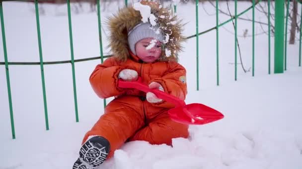 Enfant heureux s'amuser à jouer dans le parc par une journée d'hiver ensoleillée. Paysage hivernal enneigé. en plein air — Video