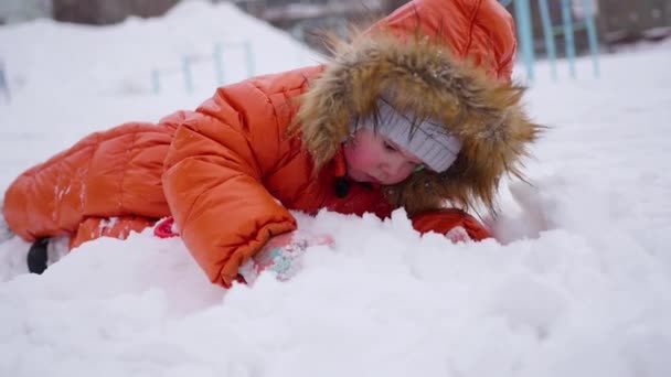 Šťastné dítě baví hrát v parku na slunný zimní den. Snow zimní krajina. na čerstvém vzduchu — Stock video