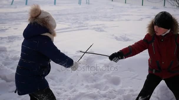 Мальчик и девочка играют на открытом воздухе зимой. Холодный зимний день — стоковое видео