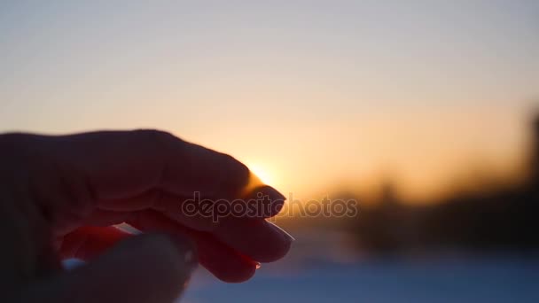 Die Sonne in seinen Händen. Frau Hand, um die Sonne auf dem Hintergrund des schönen Sonnenuntergangs am Horizont zu fangen. Natur. — Stockvideo