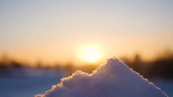 Mädchen bläst Schnee mit den Händen im Hintergrund des Sonnenuntergangs. Frostiger Wintertag — Stockvideo