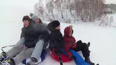 mutlu aile rides ve karlı yollarda gülümseyen snowtube. ağır çekim. kar kış manzara. açık havada spor