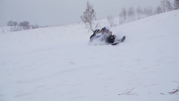 Lycklig familj rides och faller med ledyanki på snöiga vägar. Slow motion. Snö vinterlandskap. Utomhussporter — Stockvideo