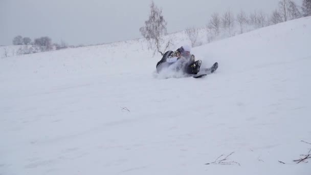 Heureux promenades en famille et tombe avec ledyanki sur les routes enneigées. Au ralenti. Paysage hivernal enneigé. Sports de plein air — Video