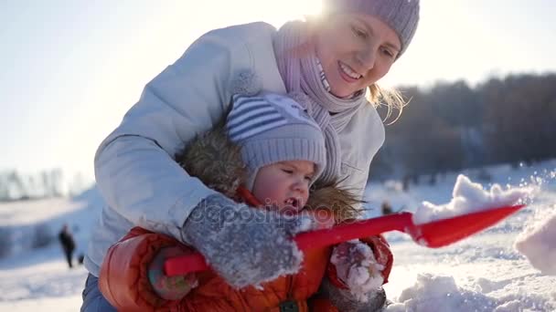 Lány játszik a baba a napsütéses téli időben. Tartja a kezében — Stock videók