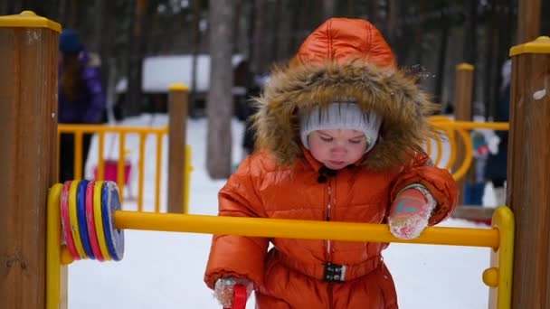 Bambino felice divertirsi giocando nel parco in una giornata invernale soleggiata. Paesaggio invernale neve. all'aperto — Video Stock