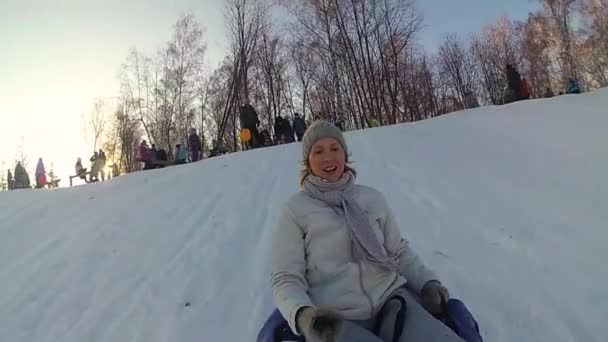 Felice ragazza cavalca e sorridente snowtube su strade innevate. Al rallentatore. neve paesaggio invernale. sport all'aria aperta — Video Stock