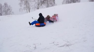 mutlu aile rides ve karlı roads.slow hareket üzerinde gülümseyen snowtube. kar kış manzara. açık havada spor