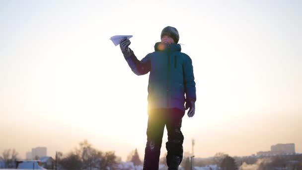 Kinder starten ein Papierflugzeug in den Himmel. Frostiger Wintertag — Stockvideo