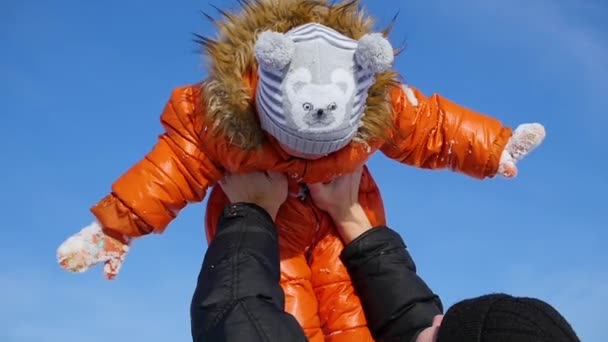 晴れた冬の時間であなたの子供と遊ぶ男。彼の腕の中で保持しています。冬の風景 — ストック動画