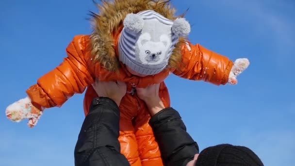 Ο άνθρωπος παίζει με το παιδί σας σε μια ηλιόλουστη χειμερινή ώρα. Κρατώντας στα χέρια του. Χειμωνιάτικο τοπίο. βίντεο 2 σε 1 — Αρχείο Βίντεο