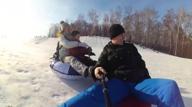 mutlu aile rides ve karlı roads.slow hareket üzerinde gülümseyen snowtube. kar kış manzara. açık havada spor