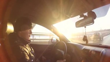 adam araba güneşli bir günde kullanıyor.