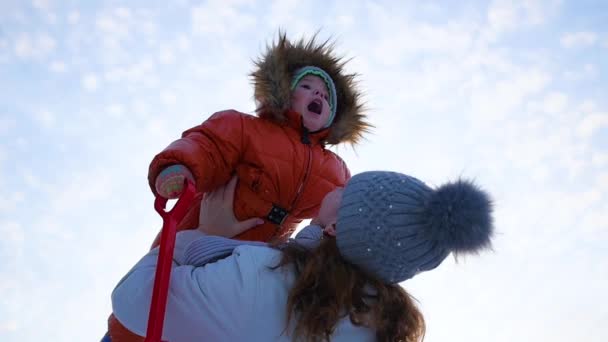 Девушка играет с ребенком в солнечное время зимой. Держаться за руки — стоковое видео