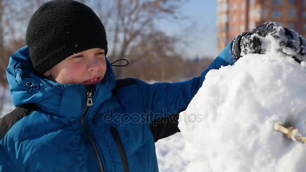 Enfant faisant un bonhomme de neige dans le terrain de jeux — Video