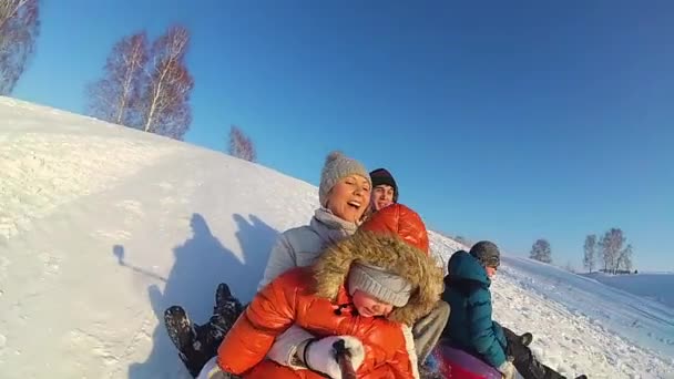 Felice famiglia cavalca e sorridente snowtube su strade innevate.rallentatore. neve paesaggio invernale. sport all'aria aperta — Video Stock