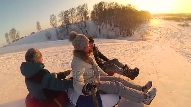 Szczęśliwa rodzina jeździ i uśmiechający się airboardowej na snowy roads.slow ruchu. Snow Zima Krajobraz. Sport na świeżym powietrzu — Wideo stockowe