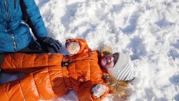 Bambini felici che giocano nel parco in una giornata invernale soleggiata. Paesaggio invernale innevato. all'aperto — Video Stock