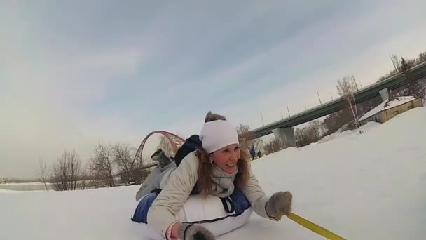 Felice famiglia cavalca e sorridente snowtube su strade innevate.rallentatore. neve paesaggio invernale. sport all'aria aperta — Video Stock