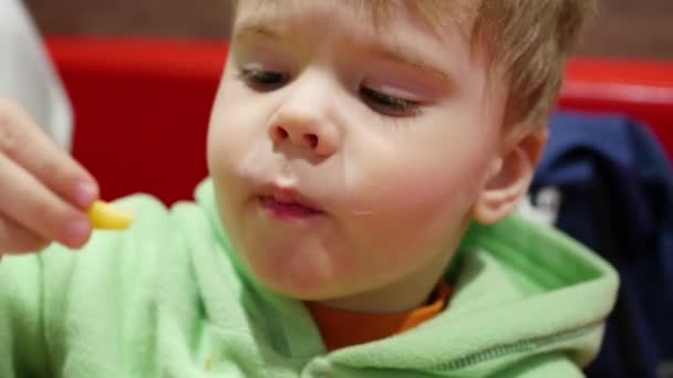 Het kind eet gebakken aardappel in fastfood-closeup — Stockvideo