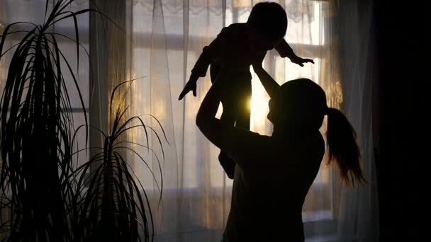 Ragazza giocando con un bambino vicino alla finestra . — Video Stock