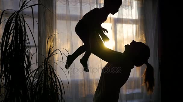 Chica jugando con un bebé cerca de ventana . — Vídeos de Stock