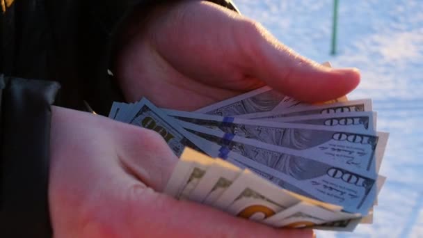 De man telt het geld in de hand buitenshuis — Stockvideo