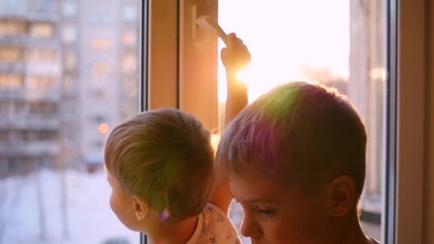 Ребенок выглядывает в окно сквозь солнце в словоблудии — стоковое видео