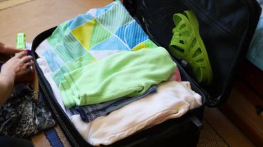 kız şeyler seyahat bavul içinde closeup koyar.