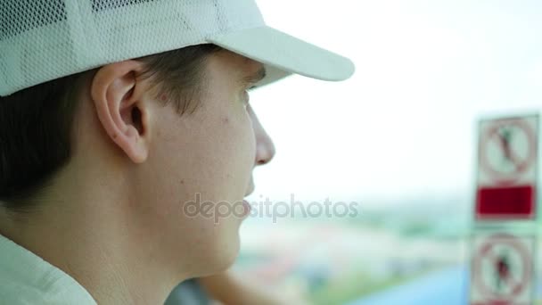 Le gars regarde par la fenêtre au soleil. Joue un rôle avec la lumière du soleil — Video