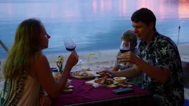 Η οικογένεια είναι δείπνο στο εστιατόριο στην παραλία. — Αρχείο Βίντεο
