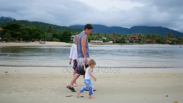 Glückliche Familie mit Kindern spaziert am Strand entlang — Stockvideo