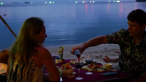 Die Familie speist im Restaurant am Strand. — Stockvideo