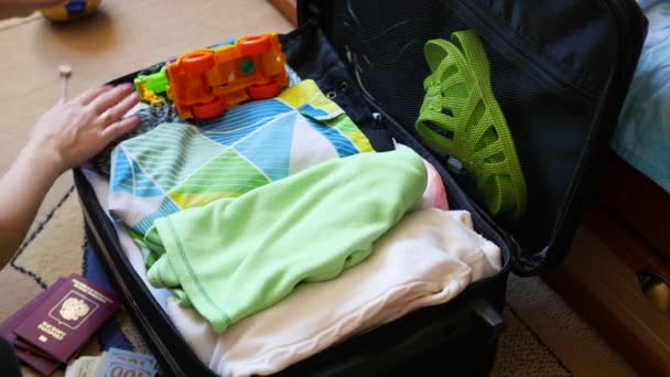 Chica pone cosas en la maleta para viajar en primer plano — Vídeos de Stock