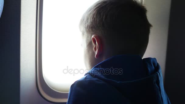 화창한 날에 비행기의 창 밖을 바라보는 아이 — 비디오
