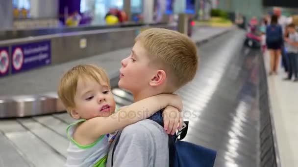 Kinderen staan in het bagageeisgebied op de luchthaven — Stockvideo