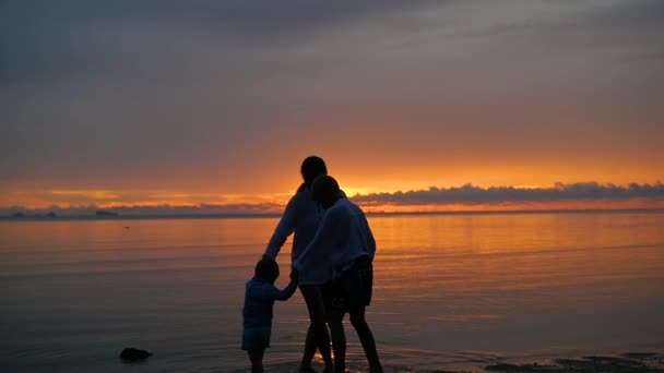 La chica con los niños ir a pasear y jugar en la playa al atardecer — Vídeo de stock