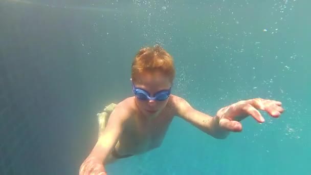 Niño feliz nada con disfrute bajo el agua en la piscina — Vídeo de stock