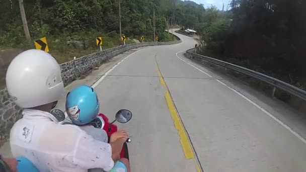 Een gelukkige familie rijdt een motor in de tropen — Stockvideo