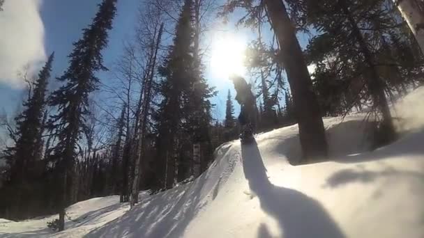 Gelukkig man op een snowboard glijden van de helling op een zonnige dag — Stockvideo