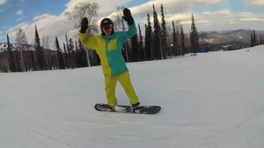 mutlu adam güneşli gün yamaçtan aşağı kayan bir snowboard üzerinde