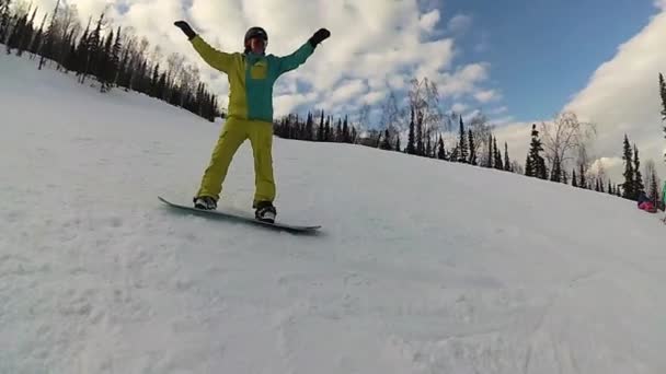 Cara feliz em um snowboard deslizando pela encosta no dia ensolarado — Vídeo de Stock