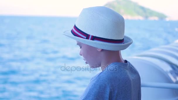Ένα παιδί στέκεται σε ένα πλωτό πλοίο και εξετάζει την απόσταση — Αρχείο Βίντεο