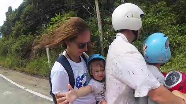 Uma família feliz monta uma moto nos trópicos — Vídeo de Stock