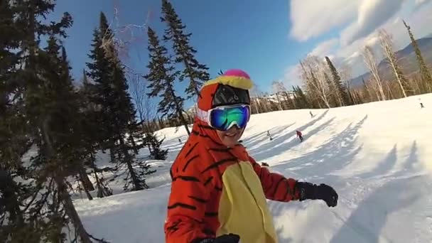 Счастливая девушка на сноуборде, скользящая по склону — стоковое видео