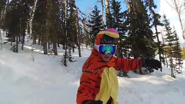 Menina feliz em um snowboard deslizando pela encosta — Vídeo de Stock