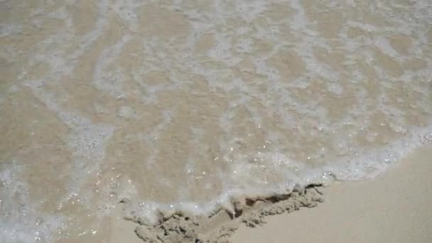 En sea wave är att tvätta bort mönstret i sanden med en solig dag — Stockvideo
